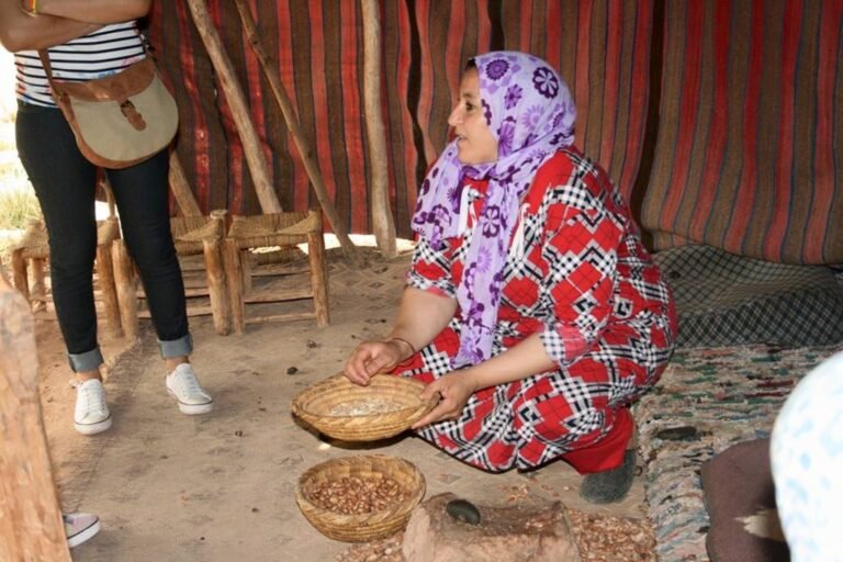 Hands engaged in the traditional artisanal process of grinding and pressing argan nuts into oil, work historically done by Amazigh women in cooperatives in southwestern Morocco