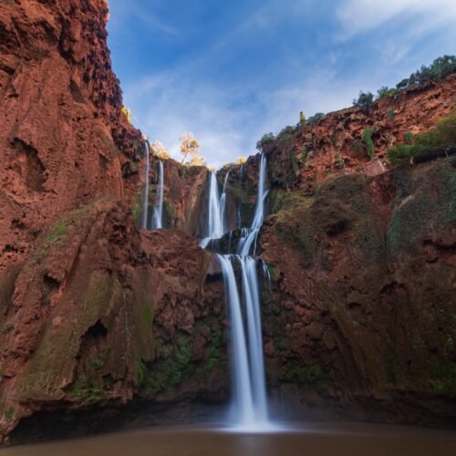 Ouzoud Waterfalls cascading over red cliffs in the Middle Atlas, the tallest and most-visited waterfall day trip from Marrakech