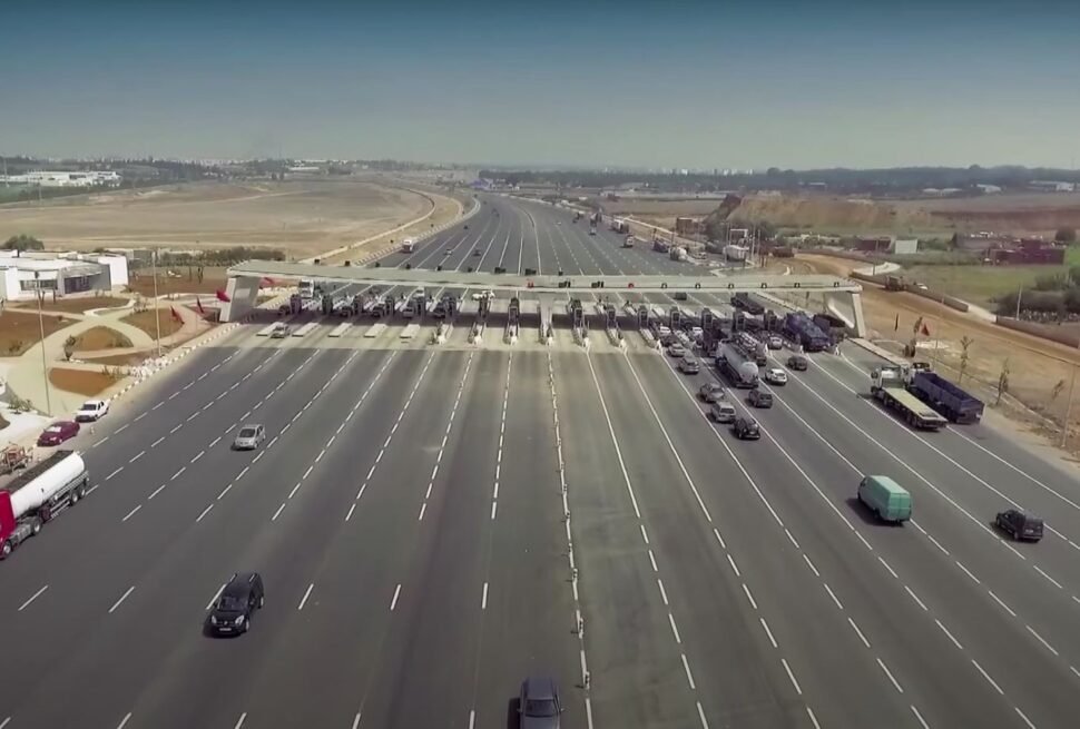 A toll payment checkpoint on a Moroccan autoroute operated by Autoroutes du Maroc, where drivers pay by cash or electronic Jawaz tag