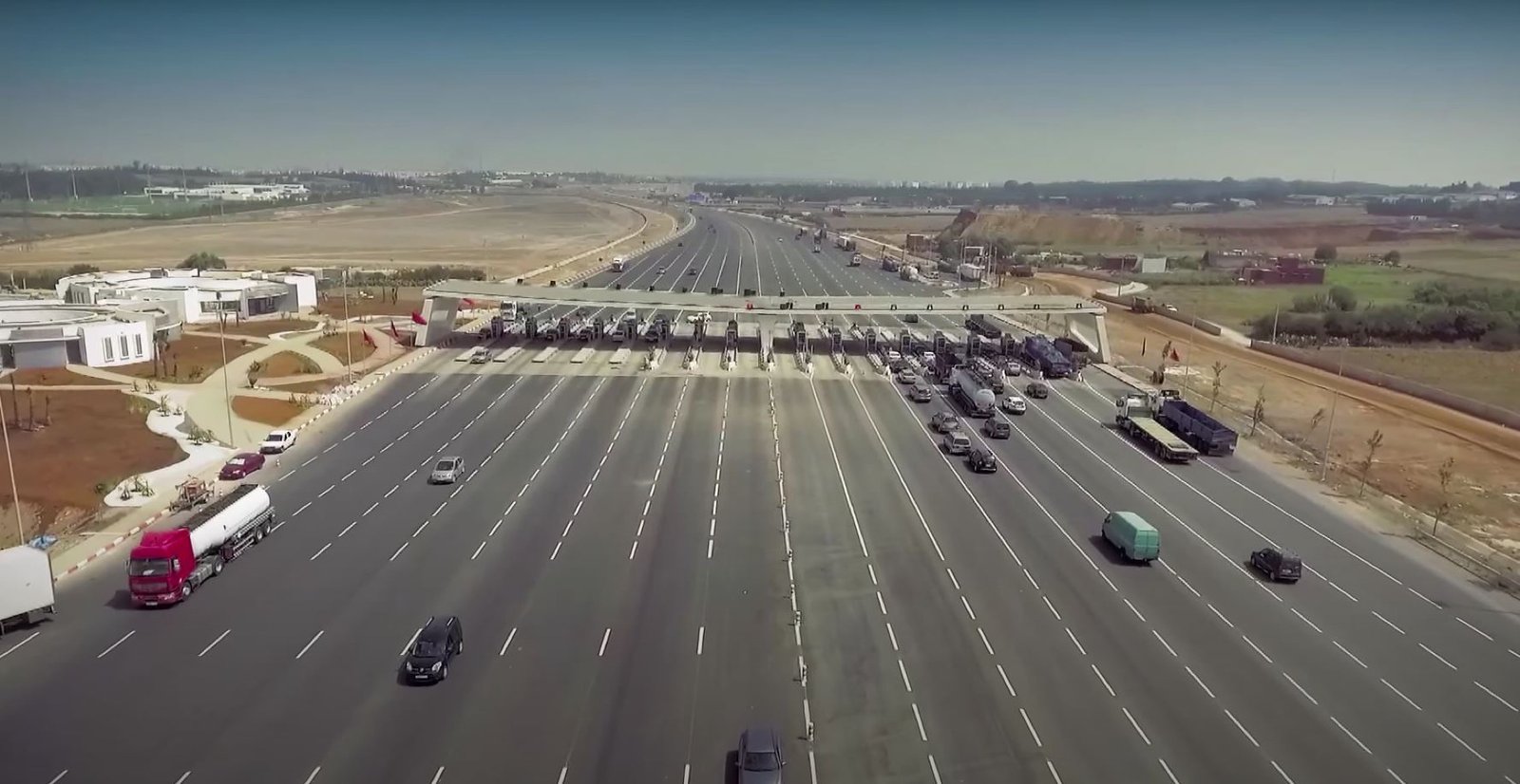 A toll payment checkpoint on a Moroccan autoroute operated by Autoroutes du Maroc, where drivers pay by cash or electronic Jawaz tag