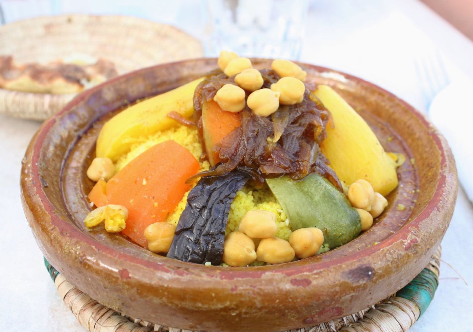 A plate of Moroccan couscous topped with steamed carrots, zucchini, turnips, and chickpeas in the traditional Friday-lunch style