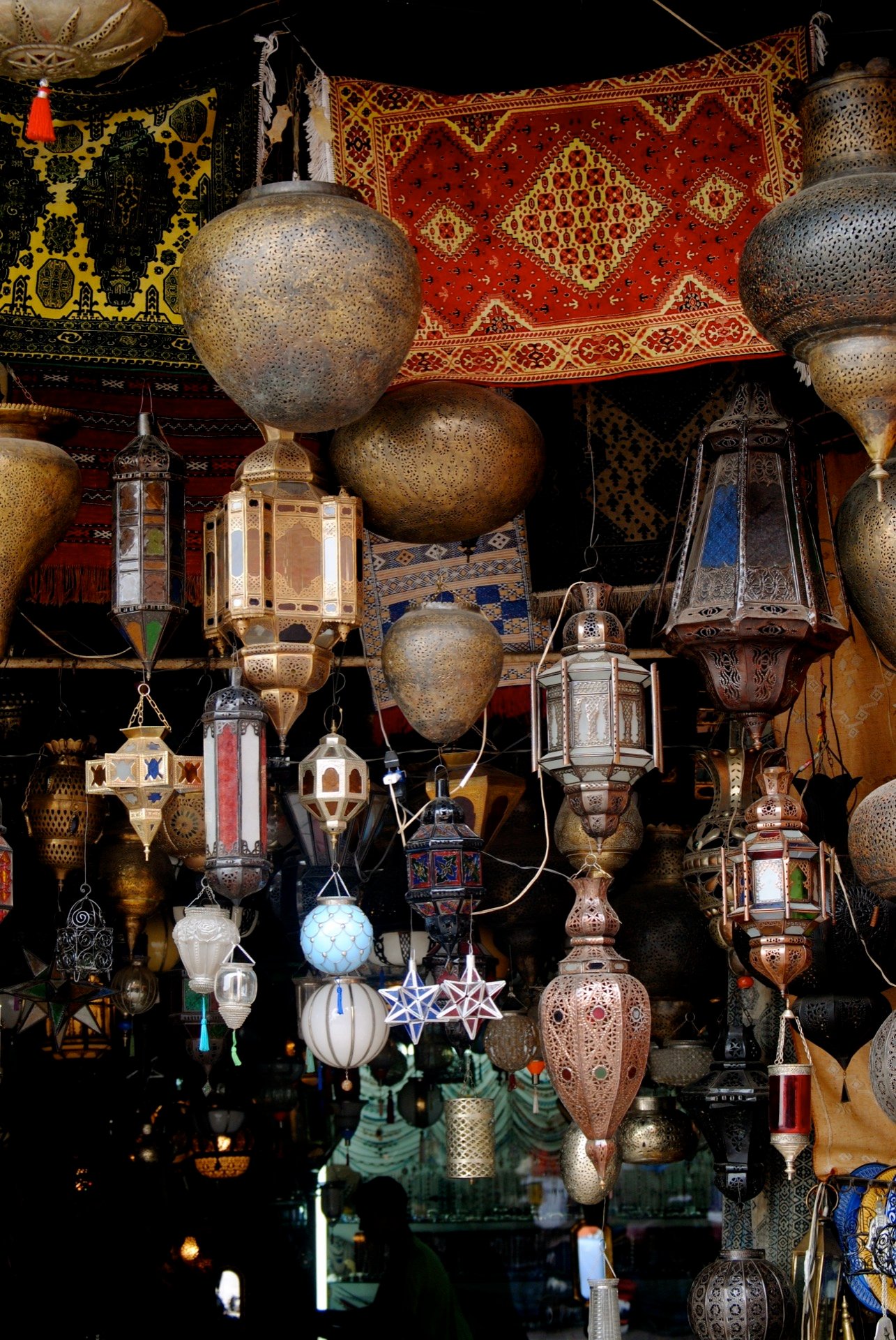 Lanternes marocaines traditionnelles en métal faites main en vente dans un souk, exposées et allumées le soir pendant le ramadan