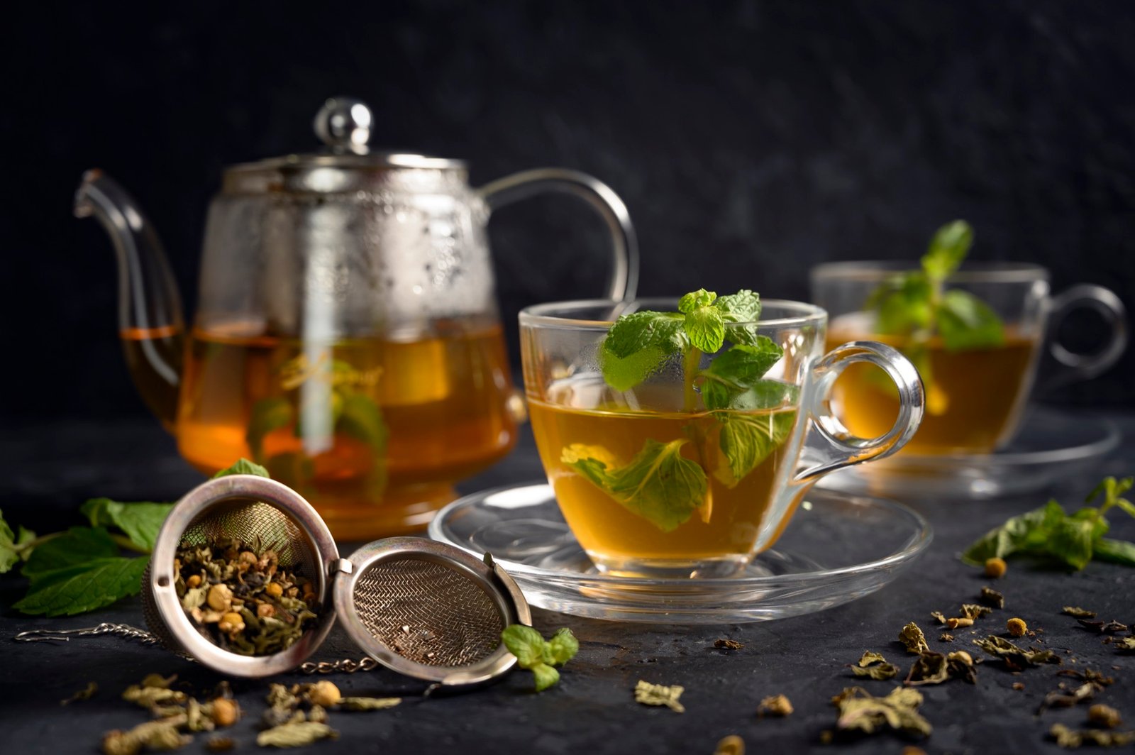 Moroccan mint tea being poured from a silver teapot held high above the glass to create a light foam on top