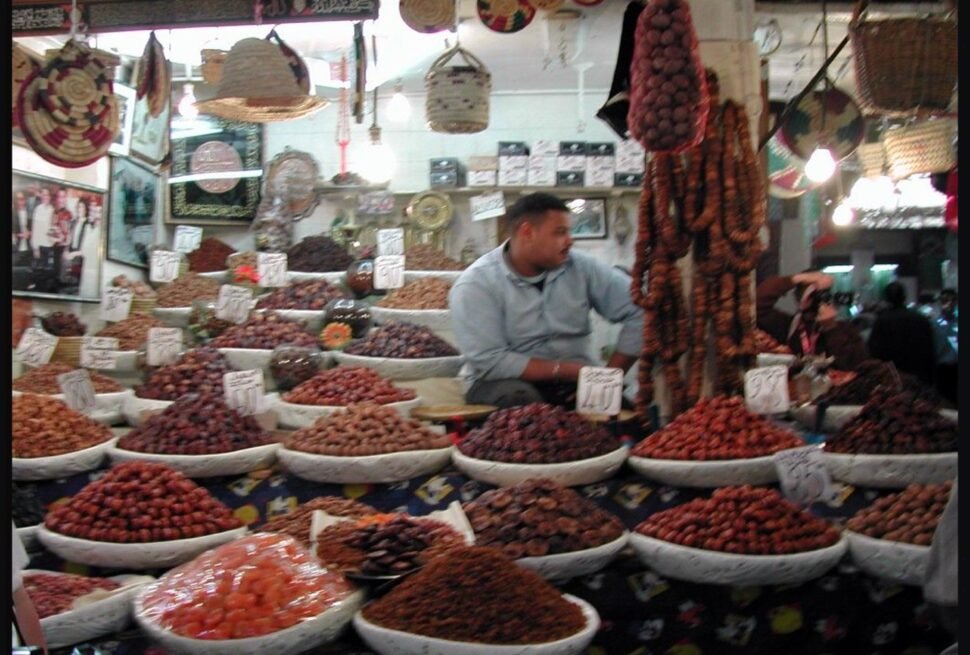Narrow covered alley of Souk Cherifia in the Marrakech medina lined with shop stalls, a typical scene for first-time visitors navigating Morocco