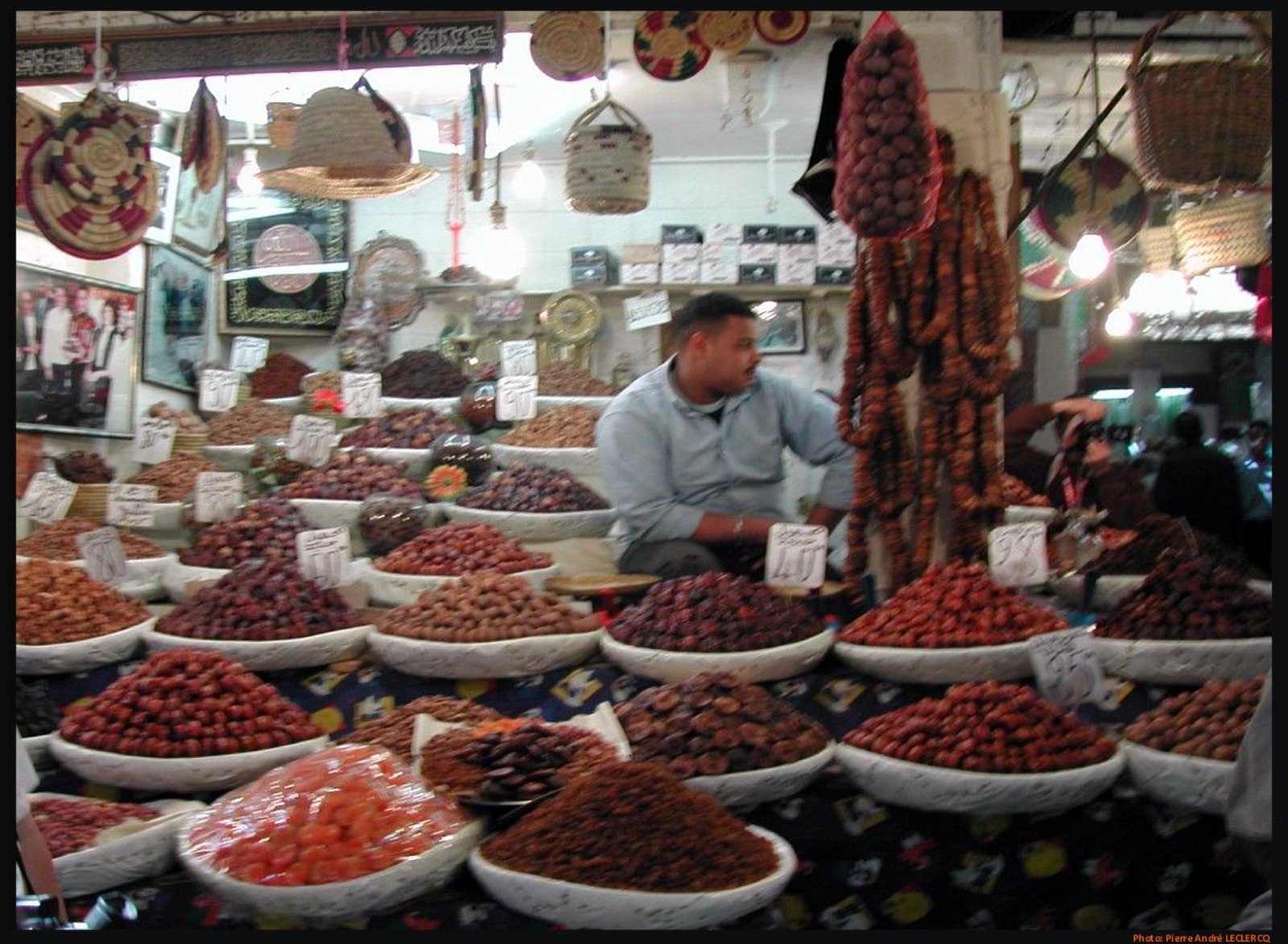 Narrow covered alley of Souk Cherifia in the Marrakech medina lined with shop stalls, a typical scene for first-time visitors navigating Morocco