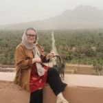 Ana Rebocho, founder of Viajar Para Marrocos, on a terrace overlooking a palm oasis in Morocco